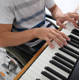 Man in rolstoel speelt piano