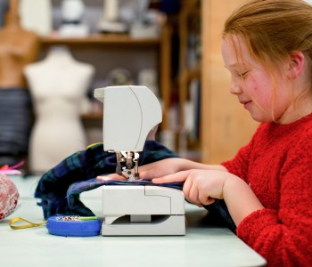 Meisje achter een naaimachine